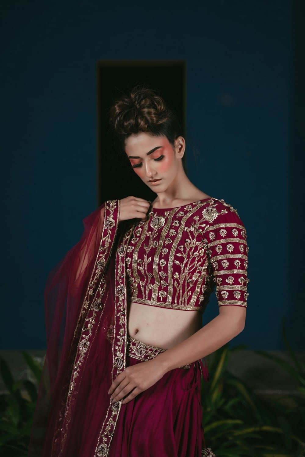 An embroidered burgundy blouse and lehenga